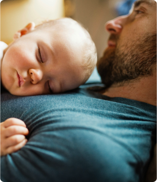 Man relaxing with young baby on chest